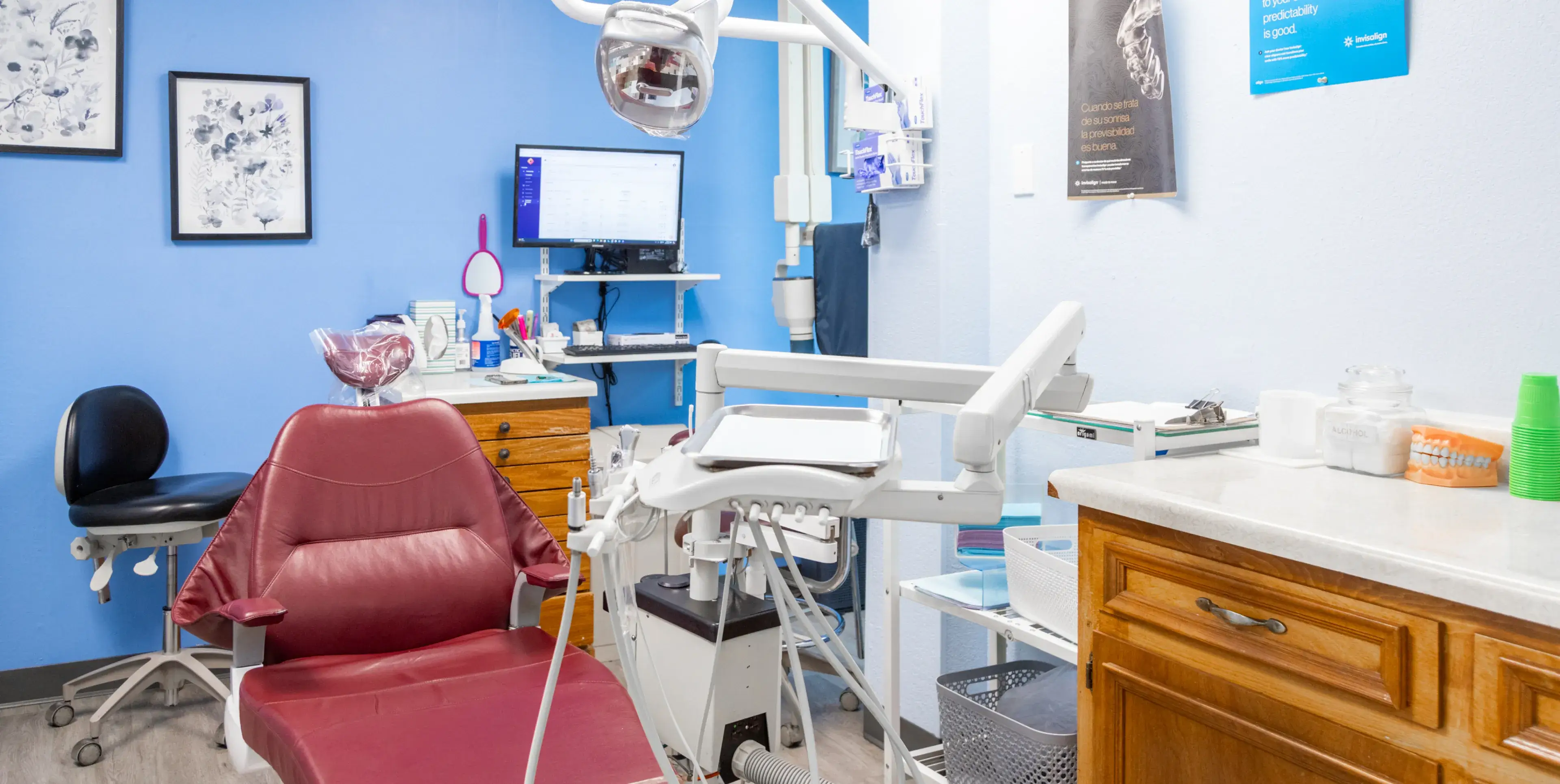 A dental office with a red chair and a blue wall.