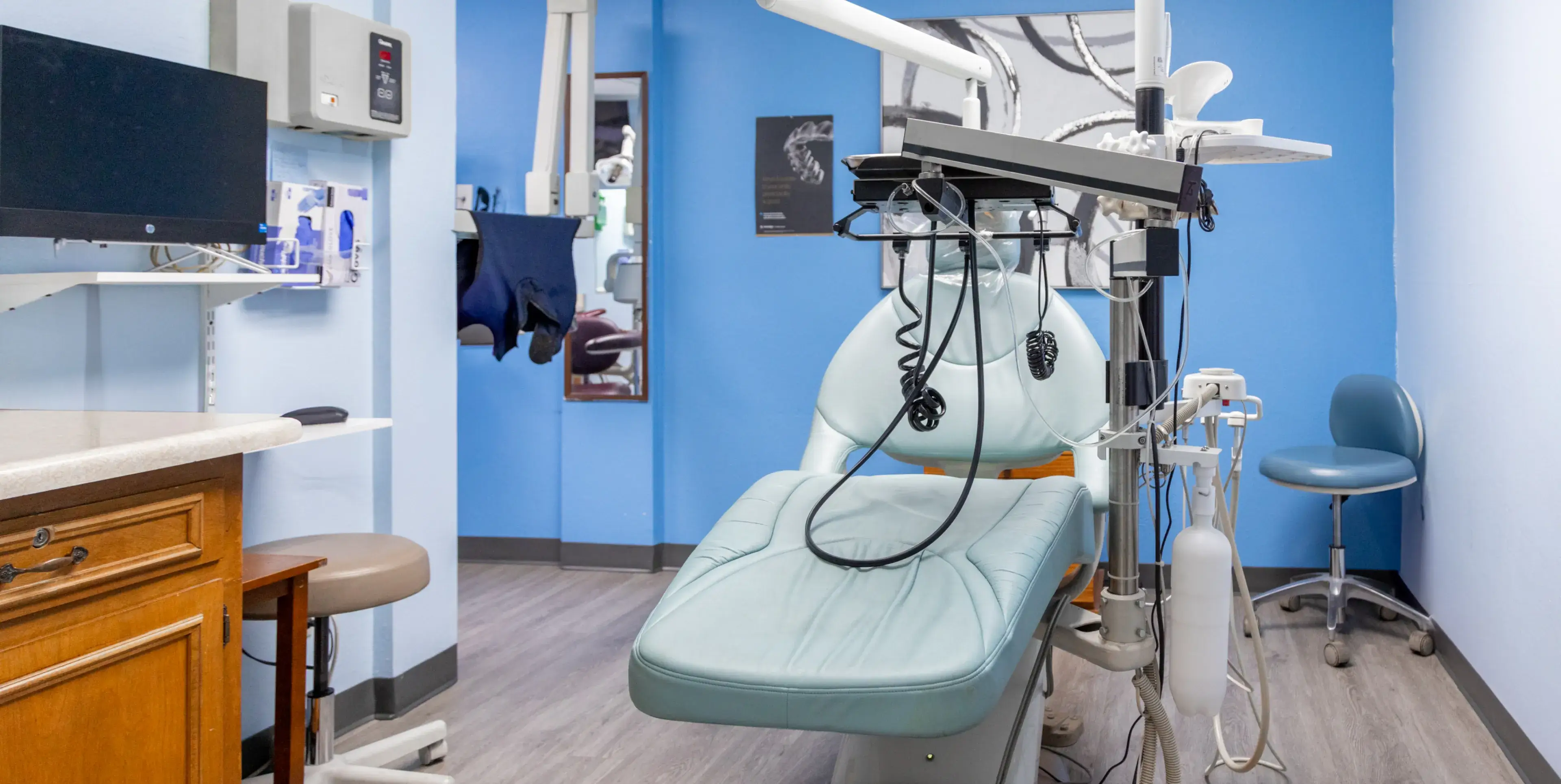 A hospital room with blue walls and a white chair.